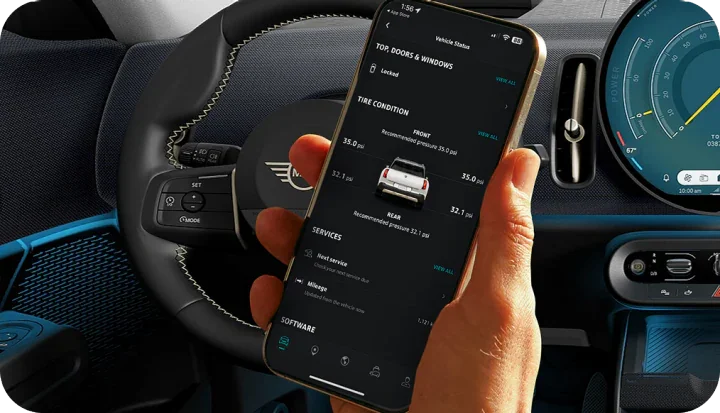 A hand holding up a phone open to the MINI App.