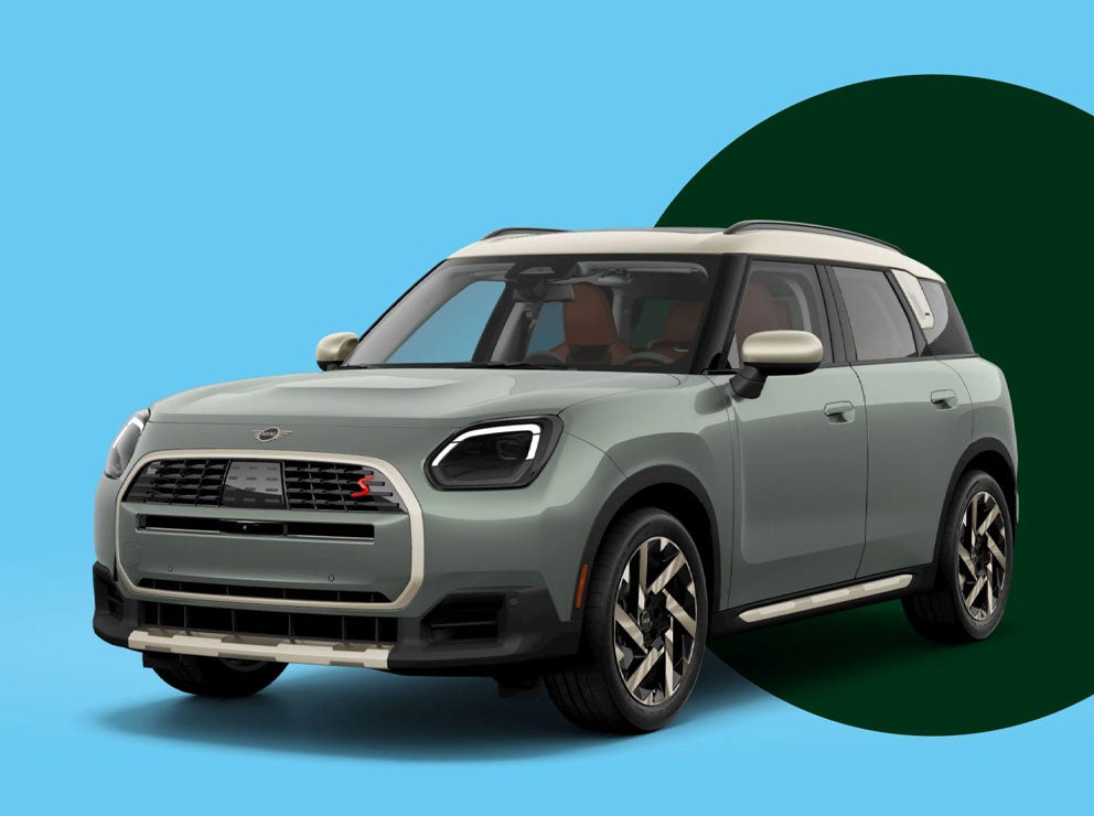 Front-to-rear view of a MINI Countryman S ALL4 with an green circle behind it against a blue background.