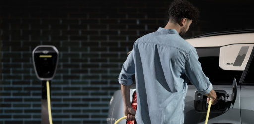 A man charges his 2025 MINI Countryman SE ALL4 against a brick wall.