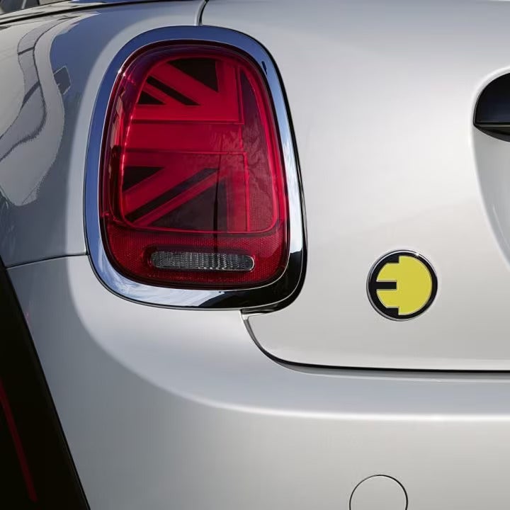 Closeup view of the back-left Union Jack tail light on a MINI Electric vehicle with shadows on the exterior paint.