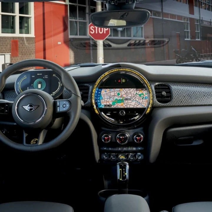 View of the front row of a MINI vehicle pictured from the back row of a MINI vehicle, zooming in on the touchscreen media display and dashboard.