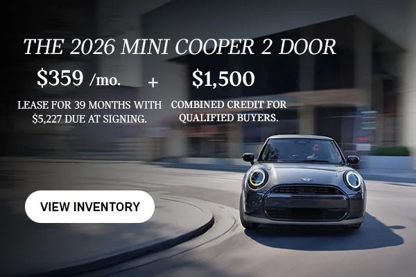 Front view of man driving grey MINI 2Door down a curved city