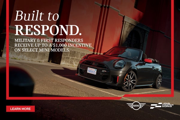 Black JCW Convertible parked by a building.